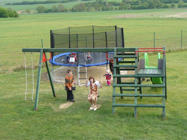 Děti na houpačkách a trampolíně